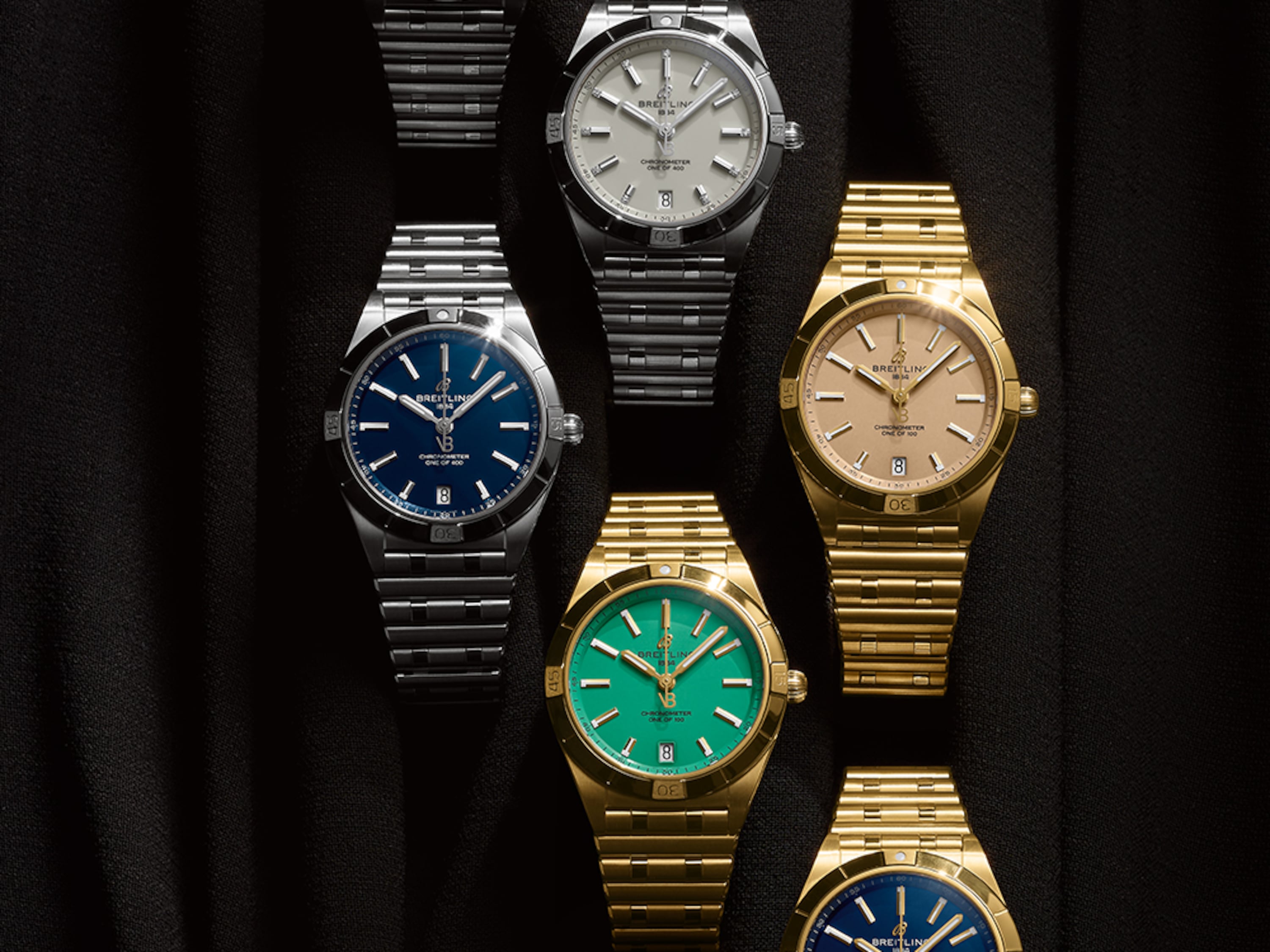 三枚銀色和三枚金色的 Chronomat 腕錶，在黑色背景下搭配不同顏色的錶盤。