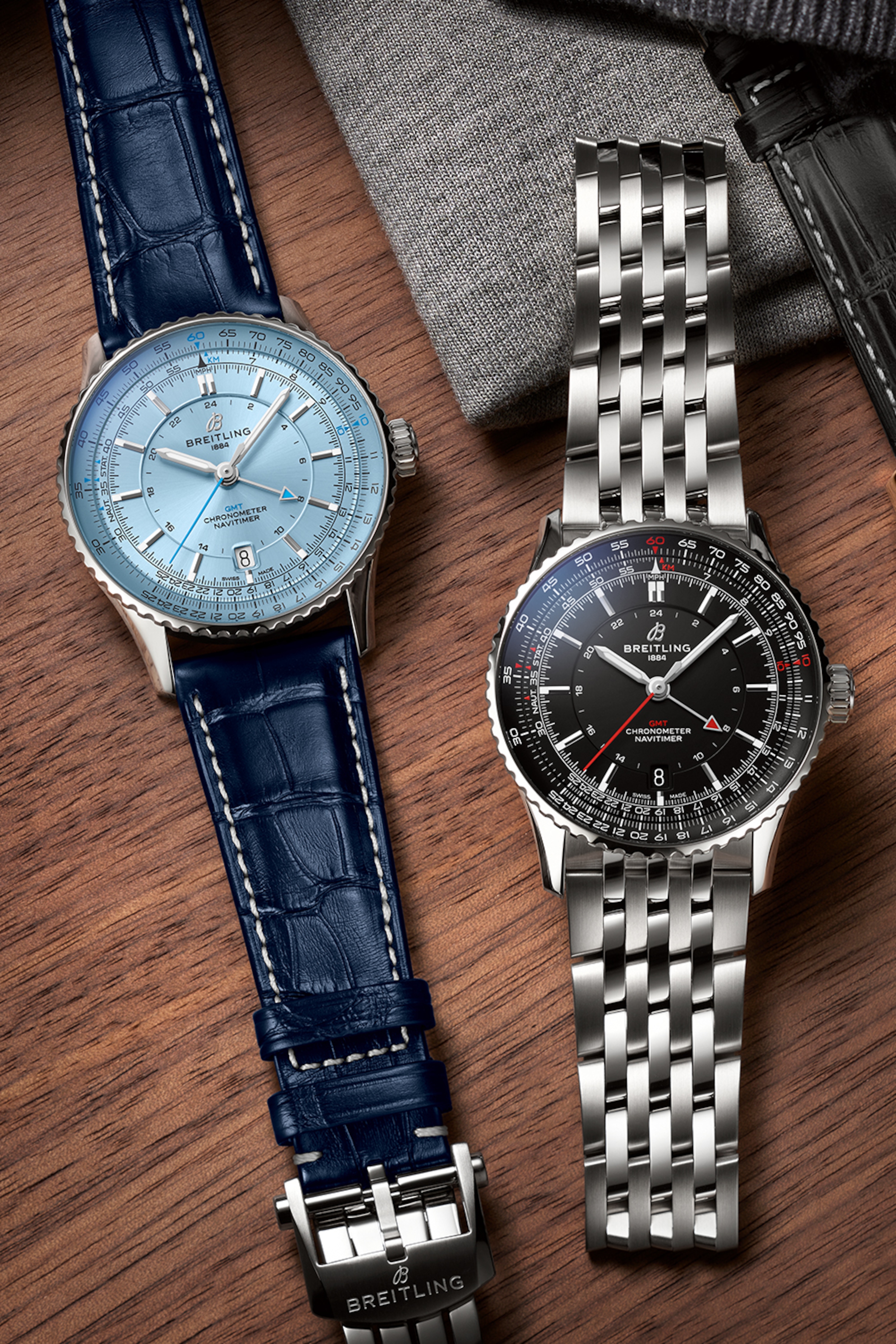 淺藍色錶盤的 Navitimer 和黑色錶盤的 Navitimer 放在桌上。
