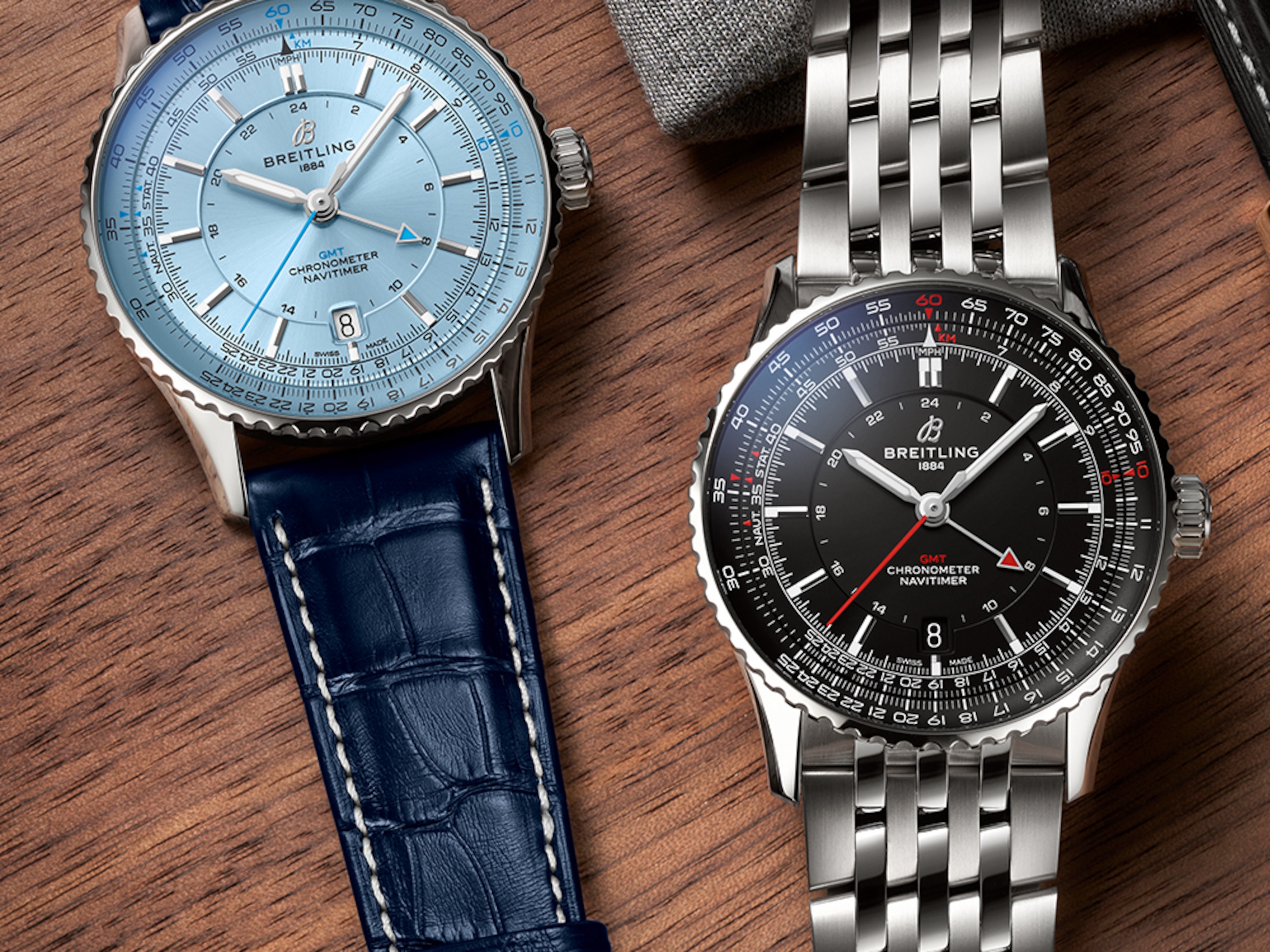 淺藍色錶盤的 Navitimer 和黑色錶盤的 Navitimer 放在桌上。